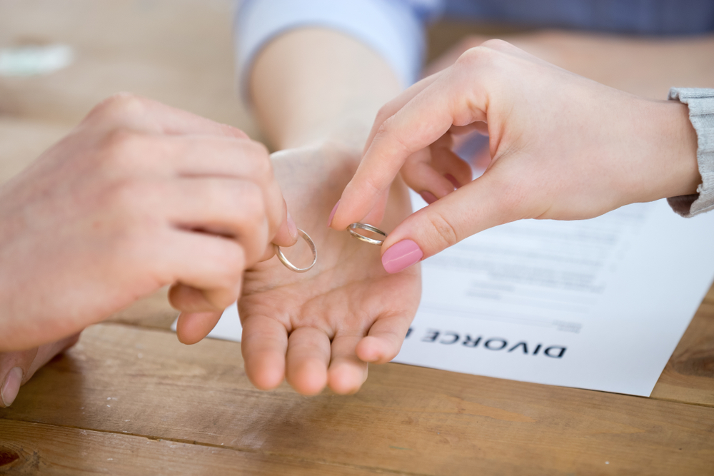 divorcing family couple give wedding rings to attorney