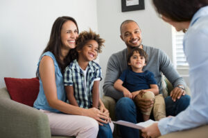 smiling parents with adopted children discussing with counselor
