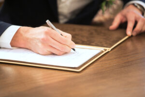 the groom signs the wedding certificate